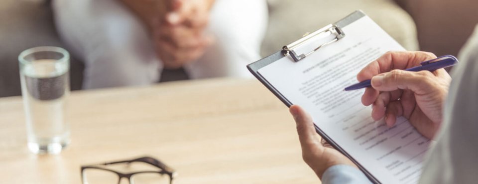 Person writing on a form