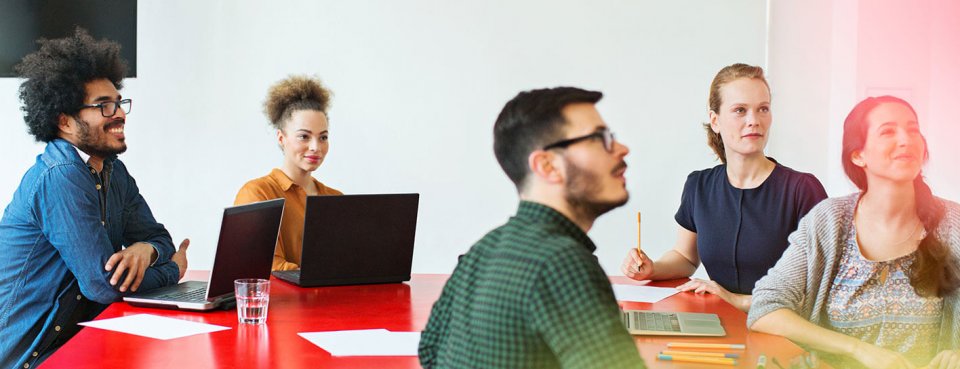 Team sat at table discussing HR training