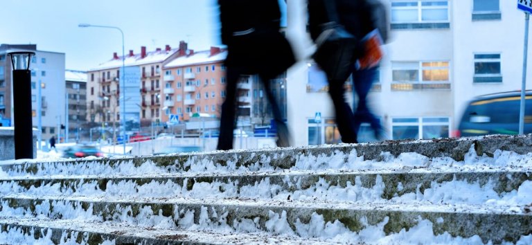 Ice cold stair covered by snow and ice. Sand is added to prevent slipping.