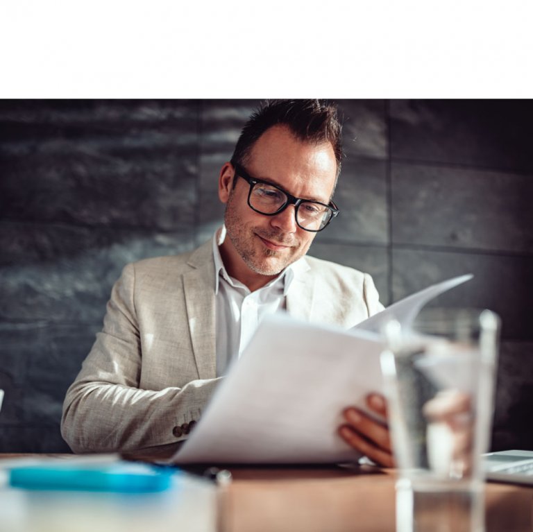 A ceo looking over CVs and documents checking a potential employees right to work