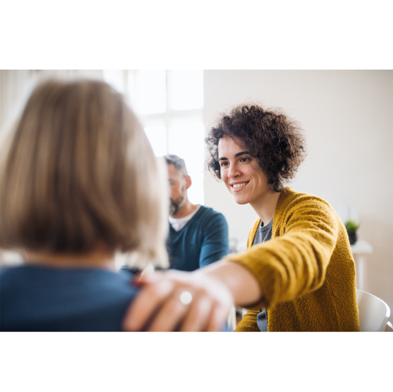 Woman putting her hand on shoulder of another woman to support mental health